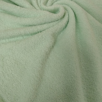 Tecido verde claro de microfibra com textura felpuda enrolado