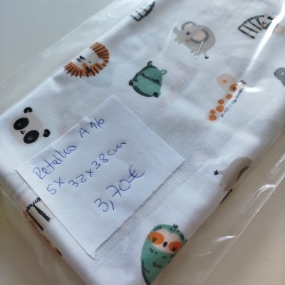 Retalho de tecido branco com estampado de animais coloridos em saco plástico