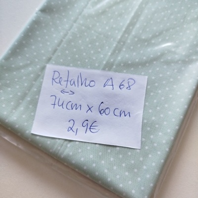 Retalho de tecido verde claro com bolinhas brancas em embalagem plástica