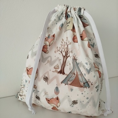 Saco de tecido com estampas de raposas e árvore em tons suaves