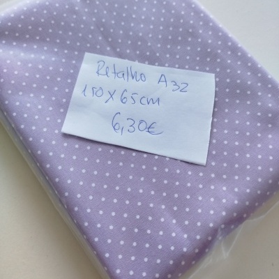 Retalho de tecido lilás com bolinhas brancas e etiqueta manuscrita