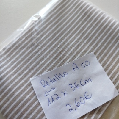 Tecido riscado branco e cinzento com etiqueta manuscrita sobre fundo branco