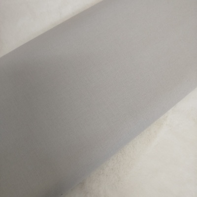 Tecido cinzento liso sobre superfície branca felpuda