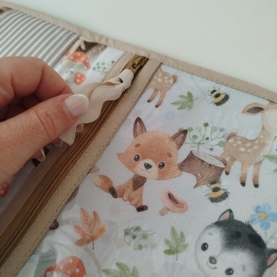 Estojo com padrão de animais e flores, fecho de correr e fita decorativa