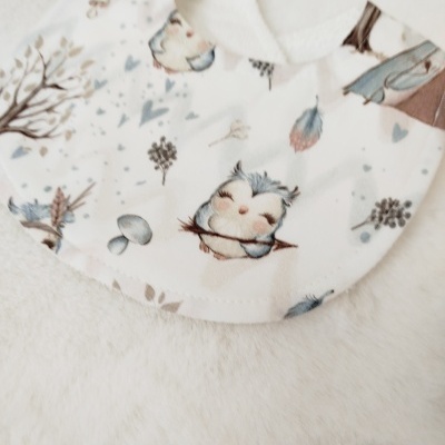 Babete branco com padrão de corujas e elementos naturais azul e creme