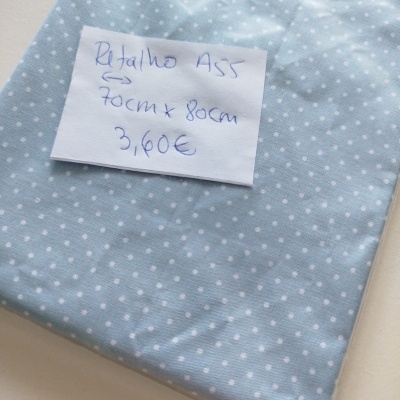 Tecido azul claro com bolinhas brancas e etiqueta manuscrita