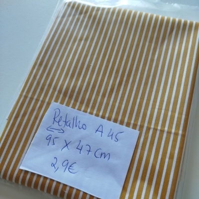 pano de tecido laranja com riscas brancas, etiquetado e embalado em plástico