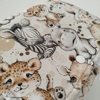 Capa com estampado infantil de animais em tons neutros com botão branco