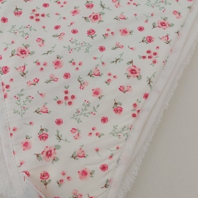 Cobertor branco com padrão de flores cor-de-rosa e verdes