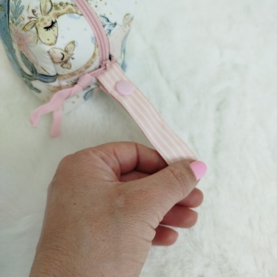 Bolsa pequena redonda com padrão de girafas e zíper rosa claro