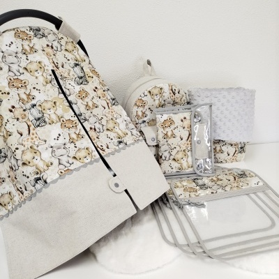 Conjunto de acessórios de bebé com padrão de animais selvagens em tecido cinza claro.