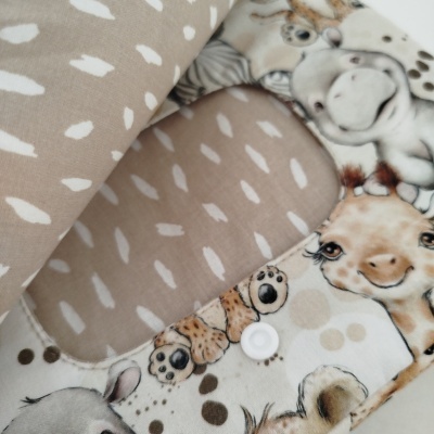 Babete infantil com padrão de pintas e estampa de animais.