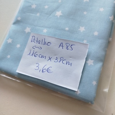 Retalho de tecido azul claro com estrelas brancas e etiqueta escrita à mão