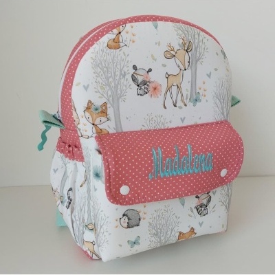 Mochila infantil com padrão de animais da floresta e aba rosa com nome bordado