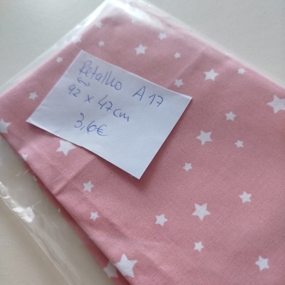 Tecido cor-de-rosa com estrelas brancas e etiqueta num saco plástico