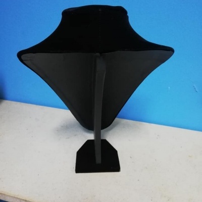 Expositor de colares em veludo preto sobre mesa branca