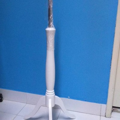 Base de madeira branca com três pernas e haste envolvida em plástico transparente