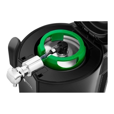 Dispositivo de torneira cromada com suporte preto e anel verde em máquina de bebidas