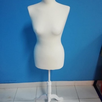 Mannequim feminino branco com suporte branco, parede azul e chão branco