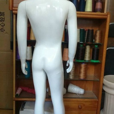Mannequin plástico branco visto de costas com cones de linha colorida ao fundo