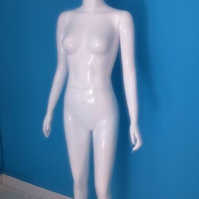 Mannequim feminino branco contra parede azul