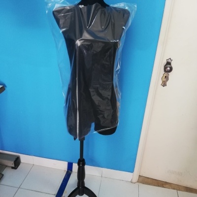 Manequim feminino preto coberto com plástico transparente em ambiente interior