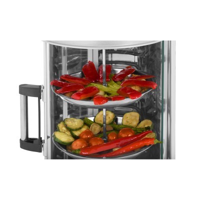 Forno elétrico vertical transparente com legumes e pimentos vermelhos no interior