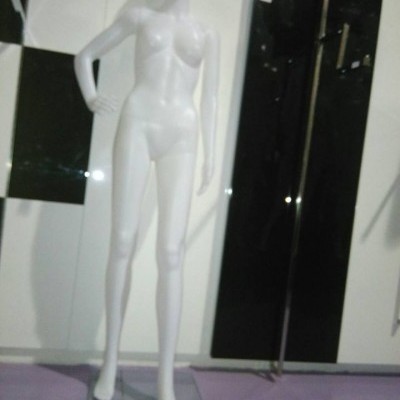 Mannequim feminino branco com rosto pintado em pé sobre base de vidro transparente