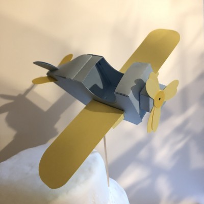 Modelo de avião em papel amarelo e azul montado numa haste