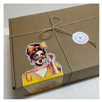Caixa de cartão castanha com cordel e autocolante colorido de mulher em estilo pop art