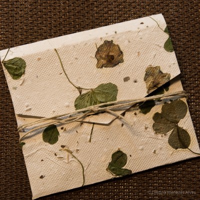 Envelope artesanal com folhas e flores secas amarrado com cordão