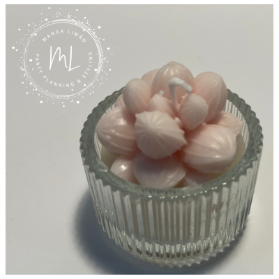 Vela rosa claro em recipiente de vidro transparente com ranhuras verticais