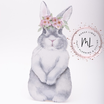 Desenho de coelho cinzento com coroa de flores cor-de-rosa e logótipo circular ao lado