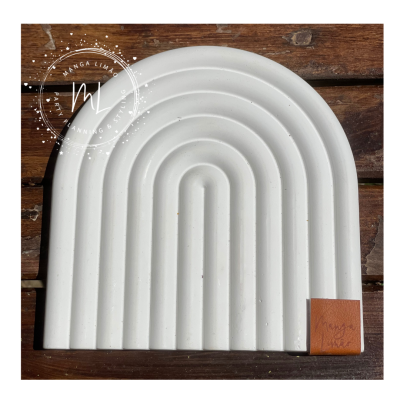 Prato branco decorativo arqueado com linhas em relevo e etiqueta de couro em cima de madeira