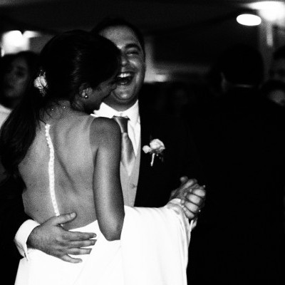 Casal a dançar em festa, mulher com vestido de noiva branco e homem com fato escuro