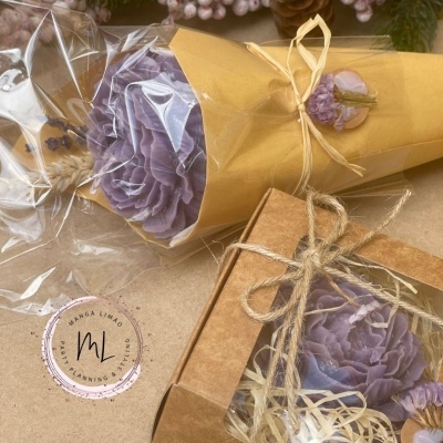 Flores decorativas roxas embaladas em papel castanho e caixa de cartão com rótulo redondo