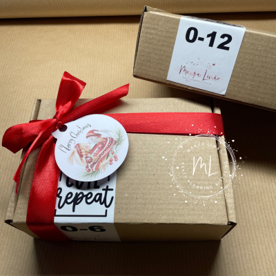 Duas caixas de cartão com etiquetas e fita vermelha com etiqueta de Natal