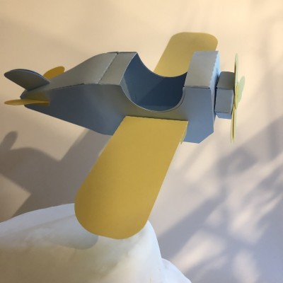 modelo de avião de papel azul e amarelo em fundo claro