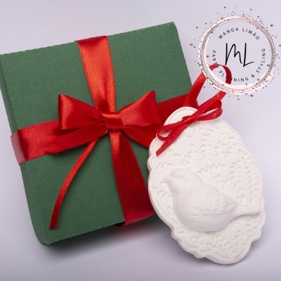 Caixa de presente verde com fita vermelha e decoração branca com relevo de pássaro e padrão floral