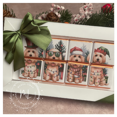 Caixa de chocolates com desenhos festivos de cães e laço verde