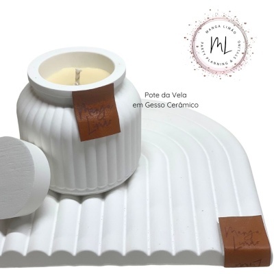 Pote de vela branco com textura canelada sobre base ondulada branca