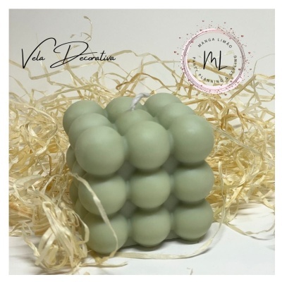 Vela decorativa verde claro em formato de cubo de esferas com palha decorativa