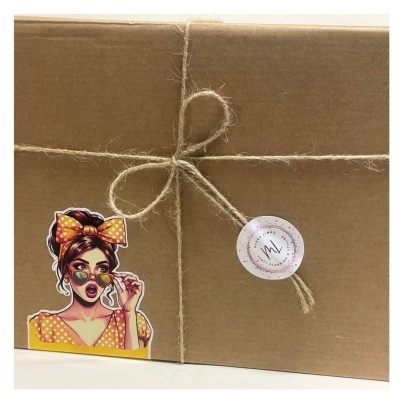 Caixa de cartão castanha fechada com corda e dois autocolantes, incluindo uma ilustração de mulher com óculos e lenço amarelo.