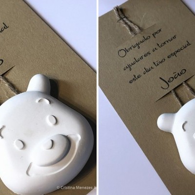 Cubo aromático branco em forma de cabeça de urso pendurado em cartão castanho com texto