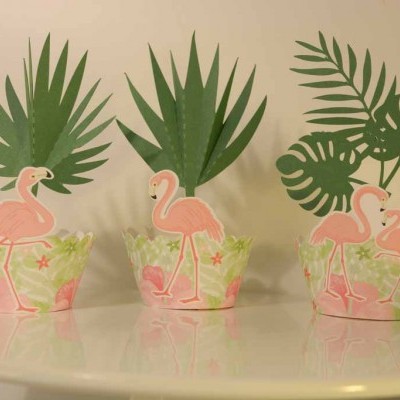 Três cachepots decorativos com flamingos cor-de-rosa e folhas tropicais verdes sobre suporte branco