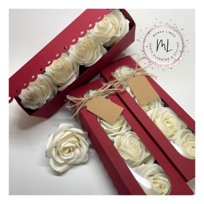 Caixas bordô com rosas brancas artificiais e etiquetas penduradas