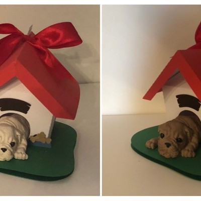 Duas casinhas de cão decorativas com cães em resina e fitas vermelhas no topo