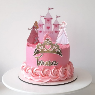 Bolo rosa decorado com figuras de princesas e castelo