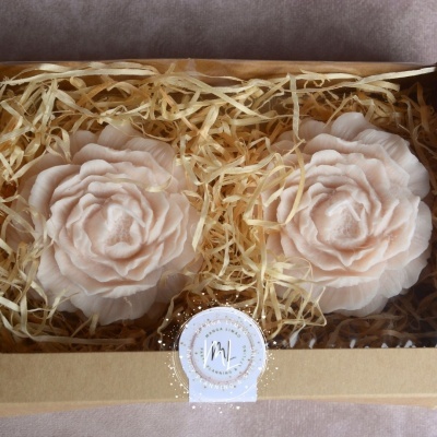 Flores artificiais cor de rosa claro em caixa com tampa transparente e enchimento de palha