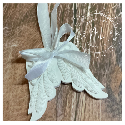 Pingente decorativo branco em forma de asas com fita de cetim sobre madeira